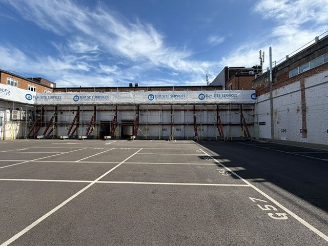 Elm Site Services branded hoarding on a scaffolding site