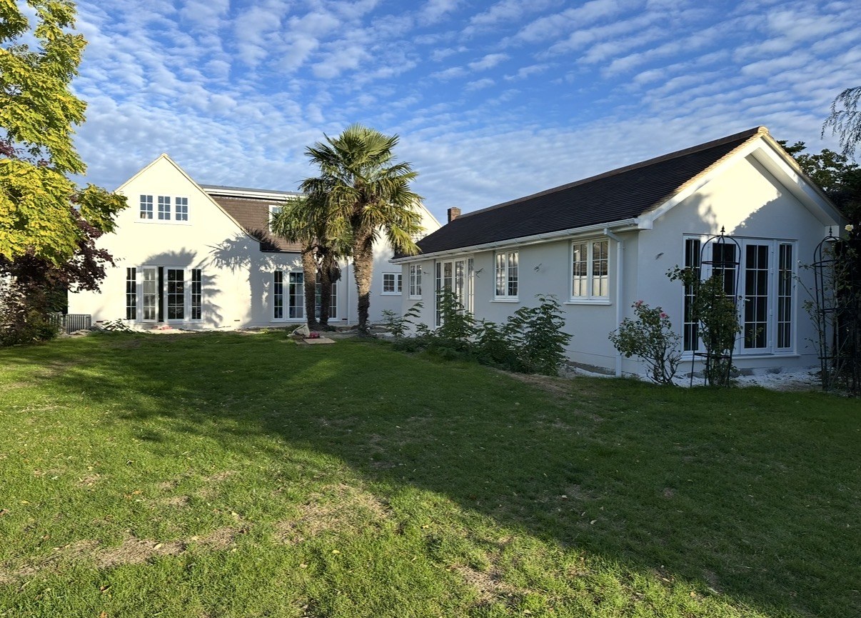 Completed modern white new-build house with dark garage — Elm Site Services